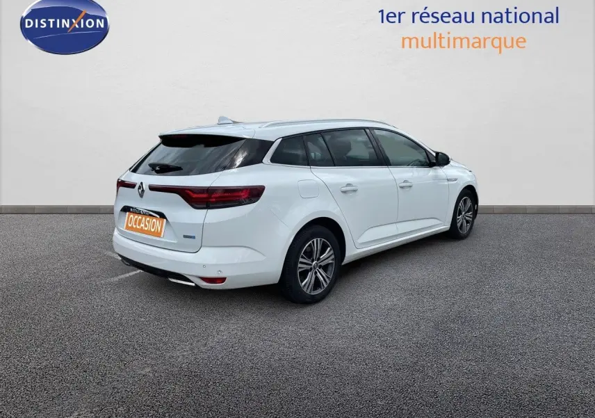 Vue 3/4 arrière droite d'une Renault Mégane Break blanc glacier avec feux arrière LED et jantes alliage.