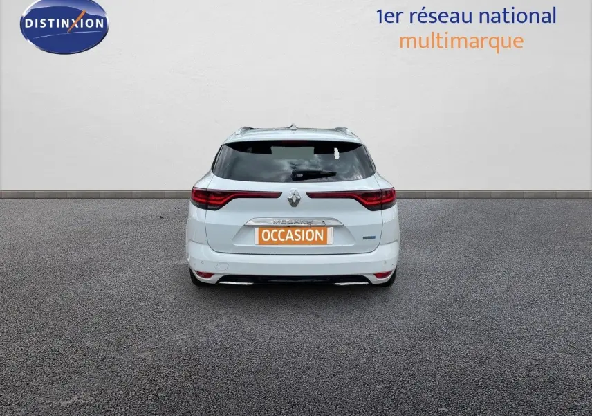 Vue arrière d'une Renault Mégane Break blanc glacier, avec feux LED et badge hybride rechargeable visible.