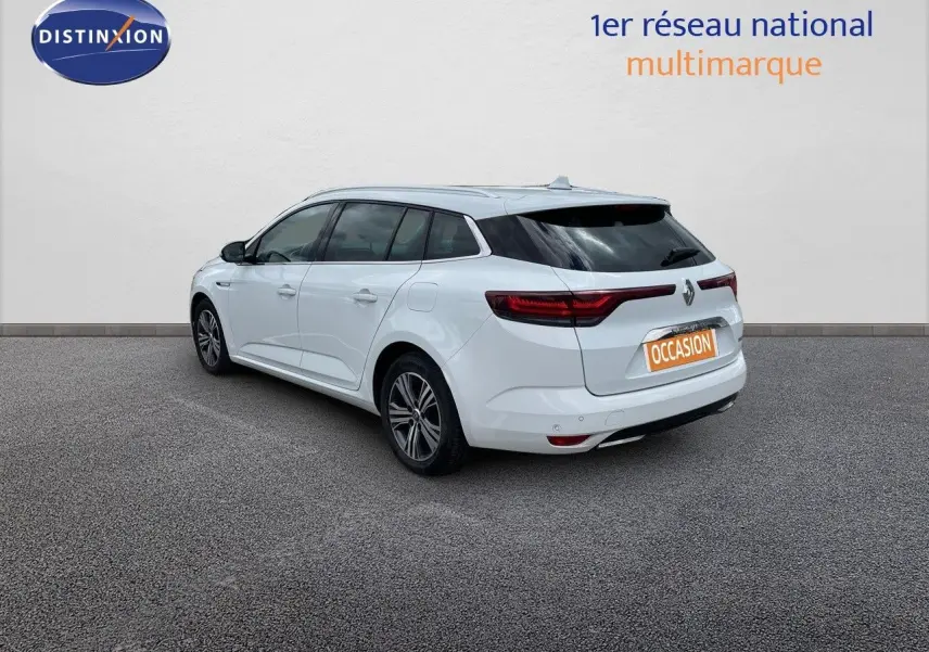Vue 3/4 arrière droite d'une Renault Mégane Break blanc glacier hybride rechargeable avec feux arrière LED distinctifs.
