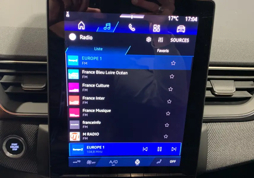 Écran tactile central affichant la radio FM dans l'habitacle du Renault Symbioz bleu Iron, version 2025.