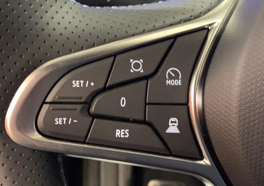 Gros plan sur les commandes noires du volant perforé du Renault Symbioz E-Tech bleu Iron, avec boutons de régulateur et mode conduite.