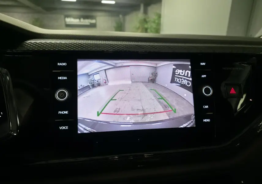 Écran tactile central affichant la caméra de recul d'une Volkswagen Polo grise, vue intérieure du tableau de bord.