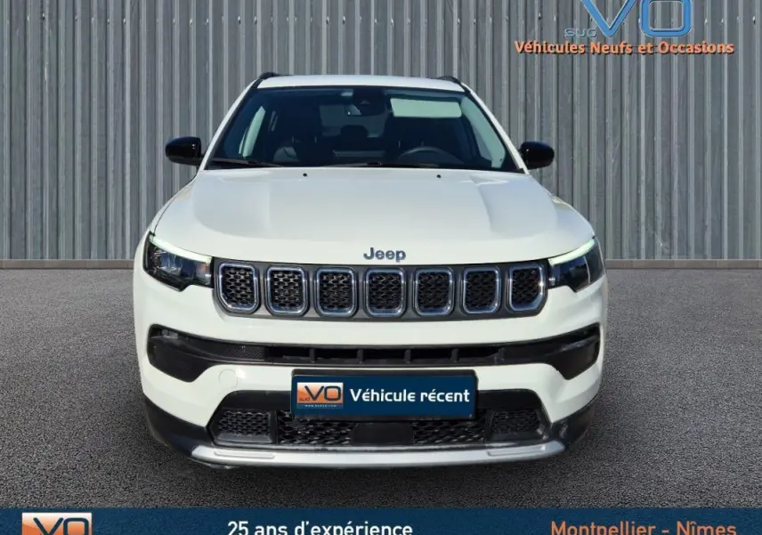 Vue frontale d'un Jeep Compass blanc 2023 avec calandre à sept fentes et phares LED distinctifs.