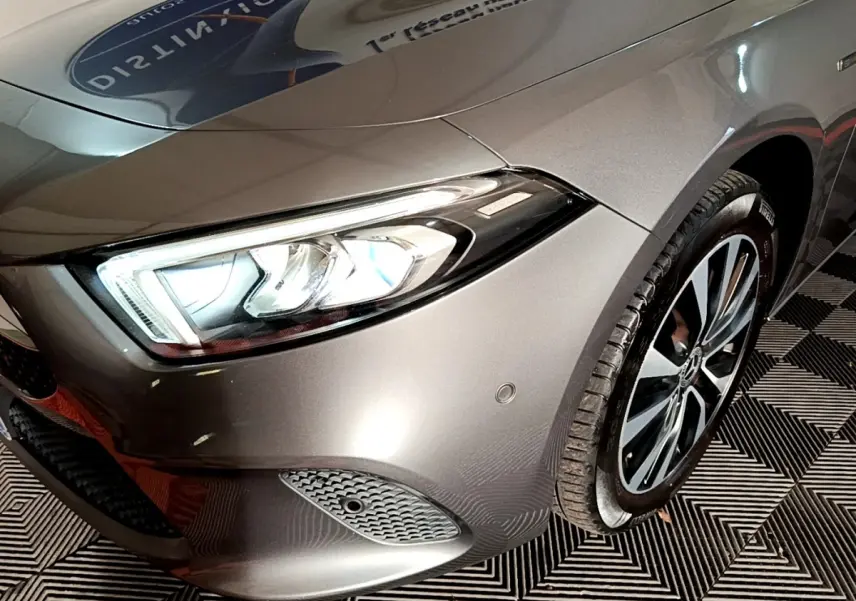 Gros plan sur l'avant droit gris foncé d'une Mercedes Classe A 250 e avec phares LED et jante alliage.