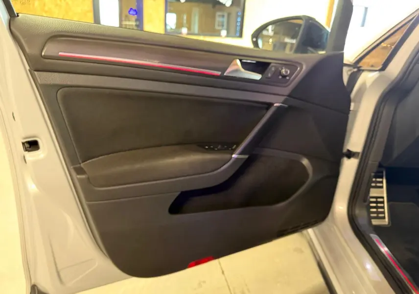 Gros plan sur le bouton de commande des phares dans l'habitacle d'une Volkswagen Golf GTI Performance gris.