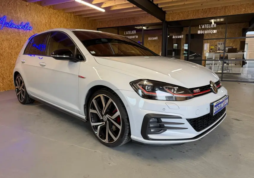 Vue 3/4 avant d'une Volkswagen Golf GTI Performance 2018 blanche avec jantes alu 19'' et étriers de freins rouges.