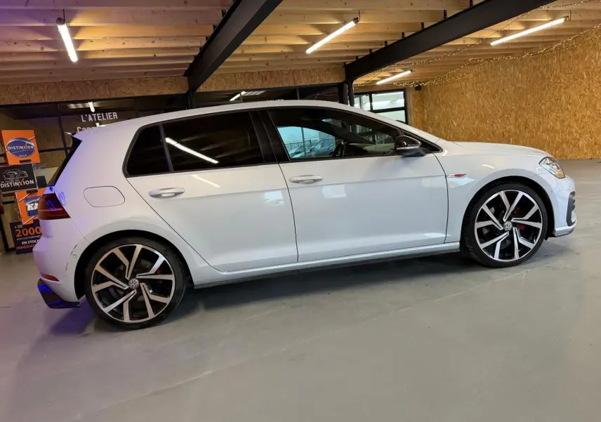 Vue latérale droite d'une Volkswagen Golf GTI Performance 2018 blanche avec jantes alu 19'' et étriers rouges.