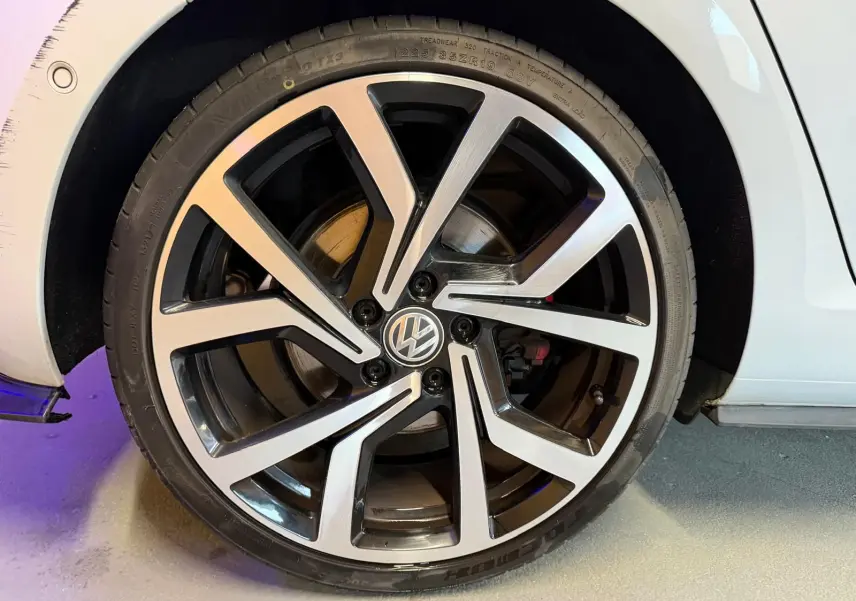 Gros plan sur la jante alu 19 pouces bicolore et le pneu d'une Volkswagen Golf GTI Performance gris.