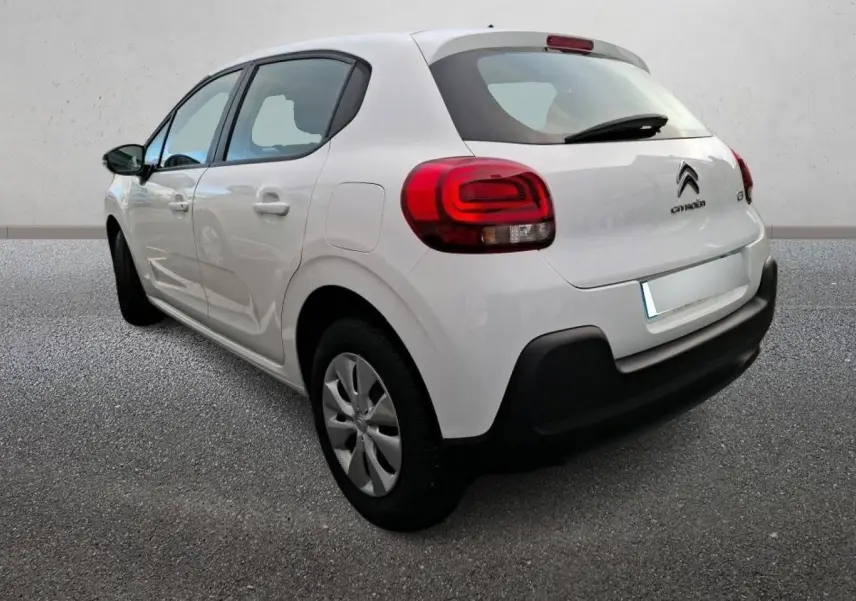 Vue 3/4 arrière droite d'une Citroën C3 blanche 2021 avec feux arrière rouges et pare-chocs noir.