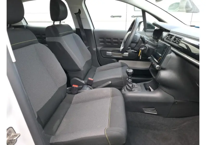 Intérieur avant de la Citroën C3 blanc, vue côté gauche, sièges gris avec surpiqûres jaunes et tableau de bord moderne.