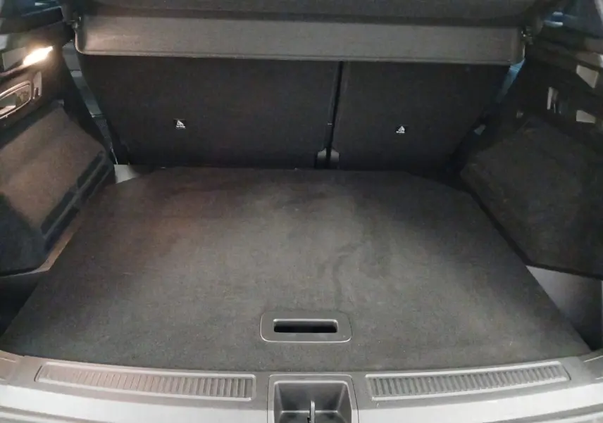 Vue du coffre arrière ouvert du Renault Austral 2024, avec plancher plat et revêtement noir uniforme.