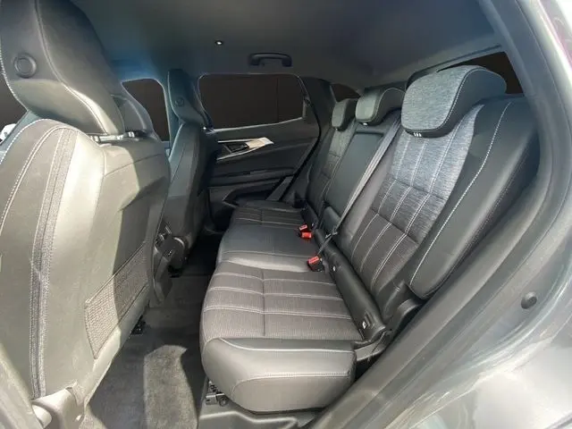 Vue latérale droite de l'intérieur arrière du Renault Austral gris schiste, avec sièges tissu noir et appuis-tête réglables.