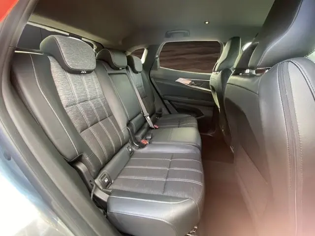 Vue intérieure arrière droite sur la banquette mixte tissu et cuir gris noir du Renault Austral E-Tech 2024, avec ceinture et appuis-tête.