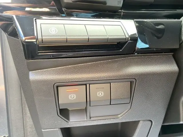 Détail des commandes de frein de parking et assistance au démarrage du Renault Austral gris schiste, vue rapprochée intérieure côté conducteur.