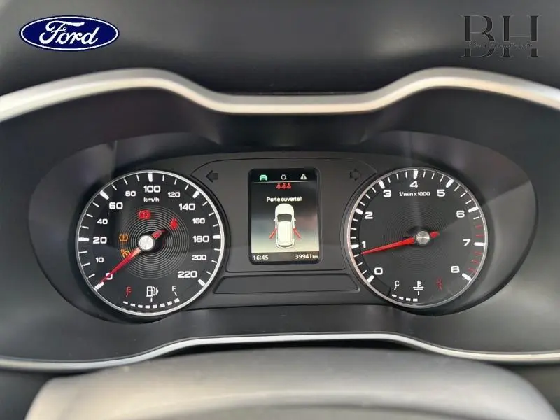 Vue rapprochée du tableau de bord noir du MG ZS 1.5 VTi-Tech 2022 avec écran central indiquant porte ouverte.