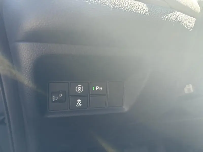 Gros plan sur les commandes noires du tableau de bord côté gauche de la Honda Jazz bleu nuit nacré 2021.