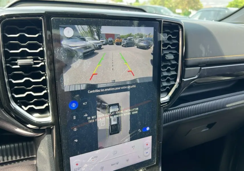 Vue rapprochée de l’écran central tactile du Ford Ranger noir agate 2025 montrant la caméra de recul et les commandes climatisation.