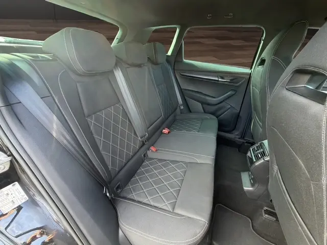 Vue intérieure montrant la banquette arrière en cuir noir avec surpiqûres losanges du Skoda Karoq 2025 côté droit.