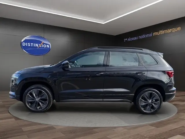 Vue latérale droite d'un Skoda Karoq noir 2025 en finition Sportline, avec jantes alliage et toit noir.