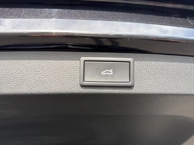Bouton d'ouverture électrique du coffre sur la partie intérieure du hayon noir du Skoda Karoq 2025.