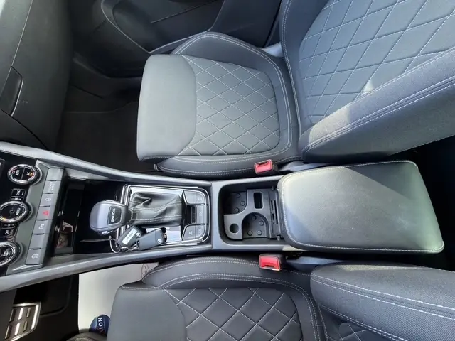 Vue plongeante sur la console centrale et les sièges noirs avec surpiqûres en losange du Skoda Karoq 2025 Sportline.