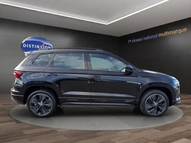 Vue latérale droite d’un Skoda Karoq noir 2025 en finition Sportline, avec jantes alliage et rétroviseurs ton caisse.