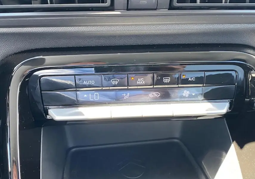 Gros plan sur la console centrale noire brillante du Citroën C3 Aircross 2026 avec commandes climatisation digitales.