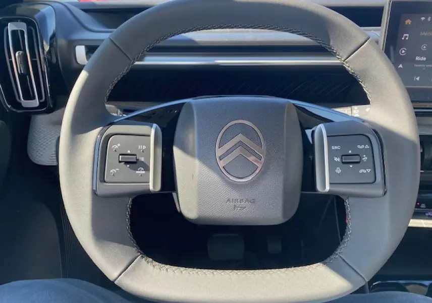 Vue intérieure centrée sur le volant gris du Citroën C3 Aircross 2026 avec commandes multifonctions intégrées.