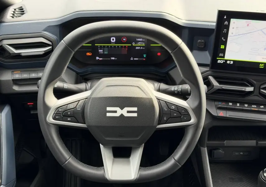 Vue frontale du volant multifonction noir et gris du Dacia Duster 2025 avec tableau de bord numérique et écran tactile GPS.