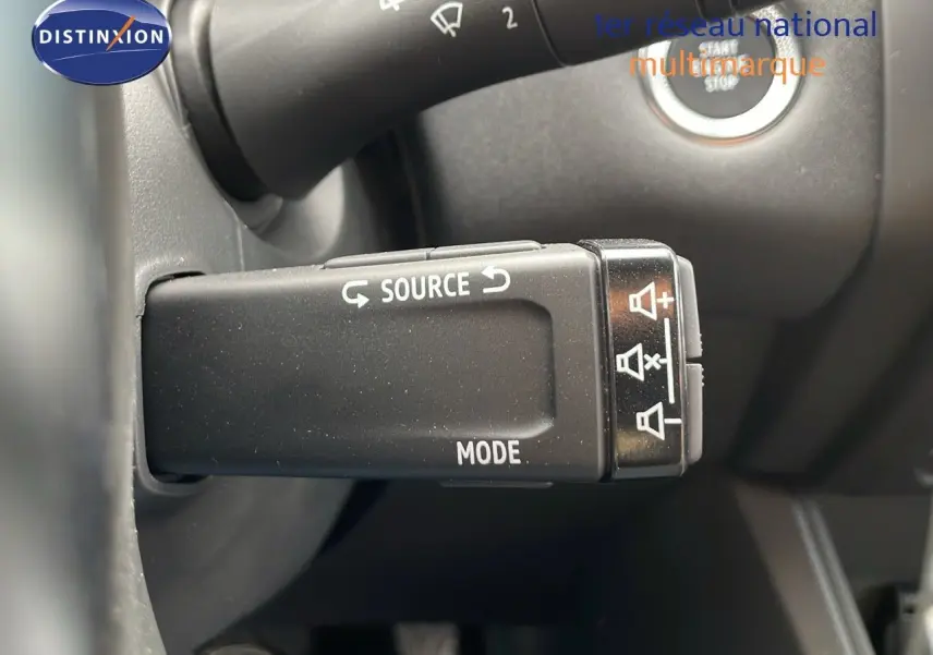 Gros plan sur la commande de source audio au volant du Renault Captur E-Tech hybride gris cassiopée toit noir 2025