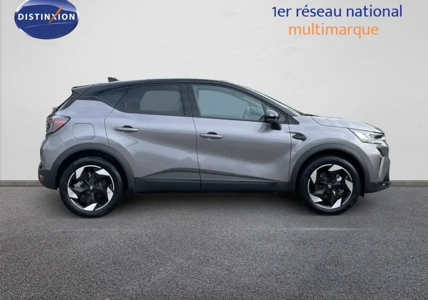 Profil droit du Renault Captur E-Tech hybride 2025 gris Cassiopée avec toit noir et jantes bicolores distinctives.