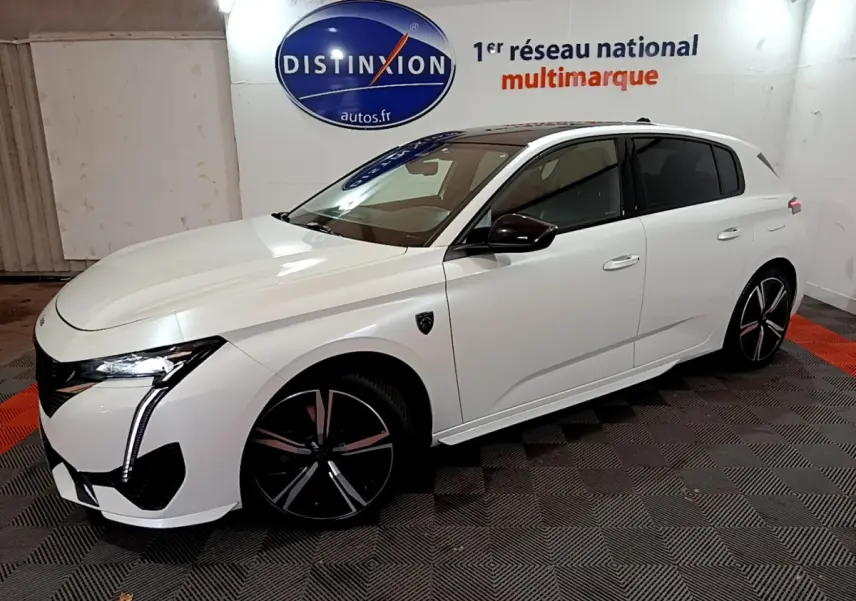 PEUGEOT 308 PHEV 180 GT blanc en 3/4 avant droit, avec phares LED et jantes noires distinctives.