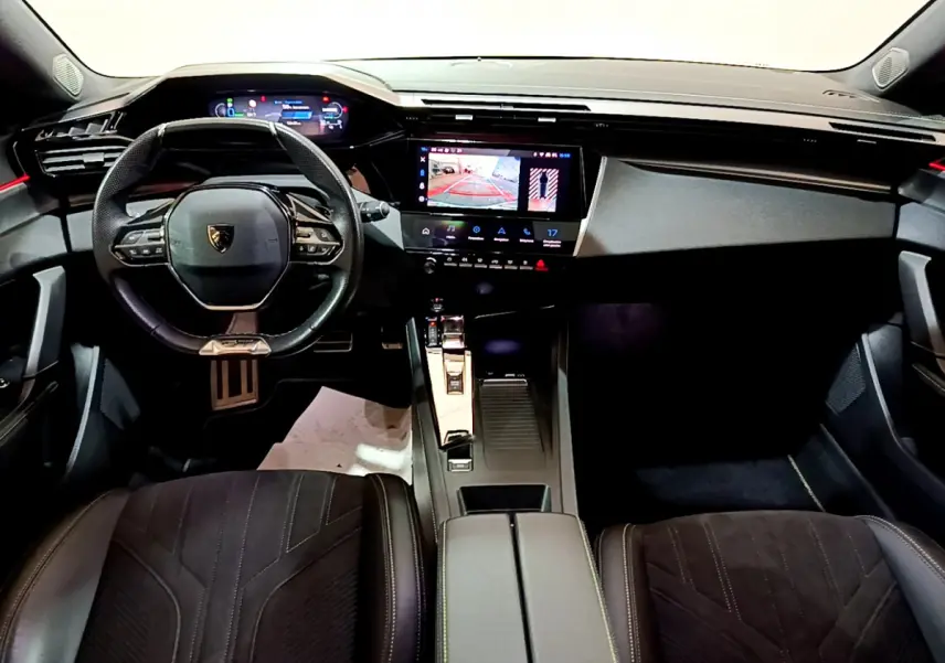 Intérieur noir de la Peugeot 308 PHEV 180 GT 2022, vue avant centrée sur tableau de bord et volant compact.