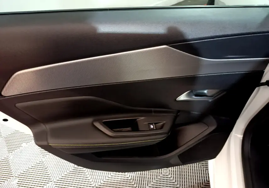 Vue rapprochée de la porte côté droit blanche du Peugeot 308 PHEV 180 E-EAT8 GT avec garniture noire et insert gris.