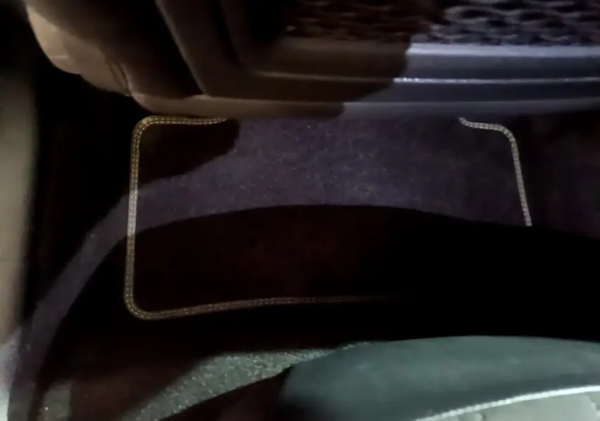 Tapis de sol noir avec surpiqûres beiges côté conducteur dans l'habitacle d'une Peugeot 308 PHEV 180 E-EAT8 GT blanche 2022.