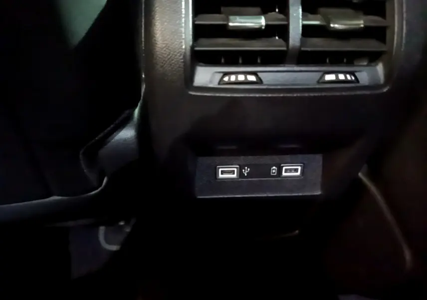 Prise USB double et ventilation arrière en gros plan dans l'habitacle noir d'une Peugeot 308 PHEV 180 E-EAT8 GT blanche