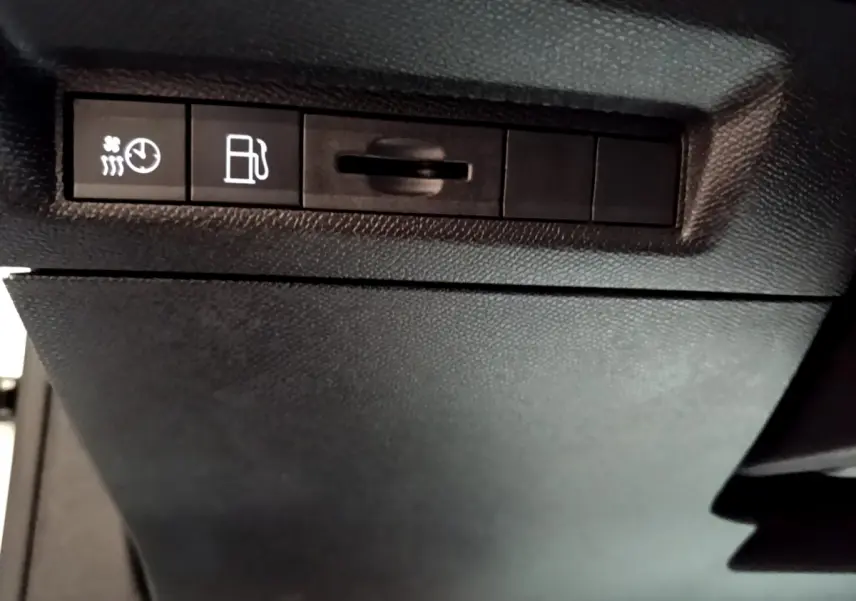 Gros plan sur les commandes de chauffage et carburant du tableau de bord d'une Peugeot 308 PHEV 180 E-EAT8 GT blanche.