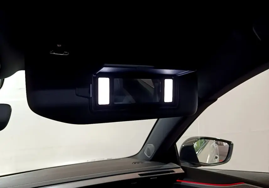 Détail intérieur du miroir de courtoisie éclairé côté passager dans la Peugeot 308 PHEV 180 E-EAT8 GT blanche 2022.