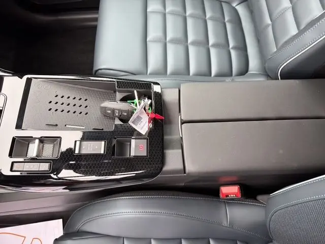 Vue intérieure centrée sur la console centrale noire brillante et les sièges gris cuir du Citroën C5 Aircross Hybrid 2026.