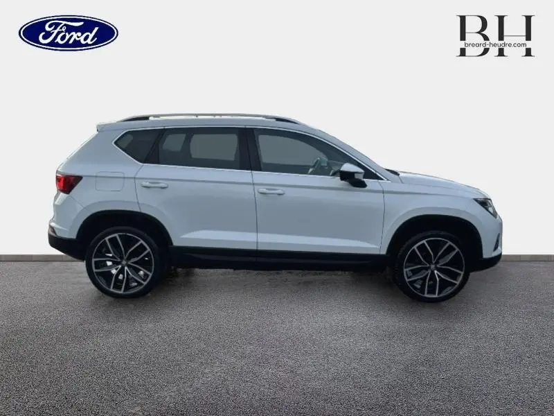 Vue de profil côté gauche d'un SEAT Ateca blanc Nevada Métal avec jantes alliage noires et toit ouvrant électrique.