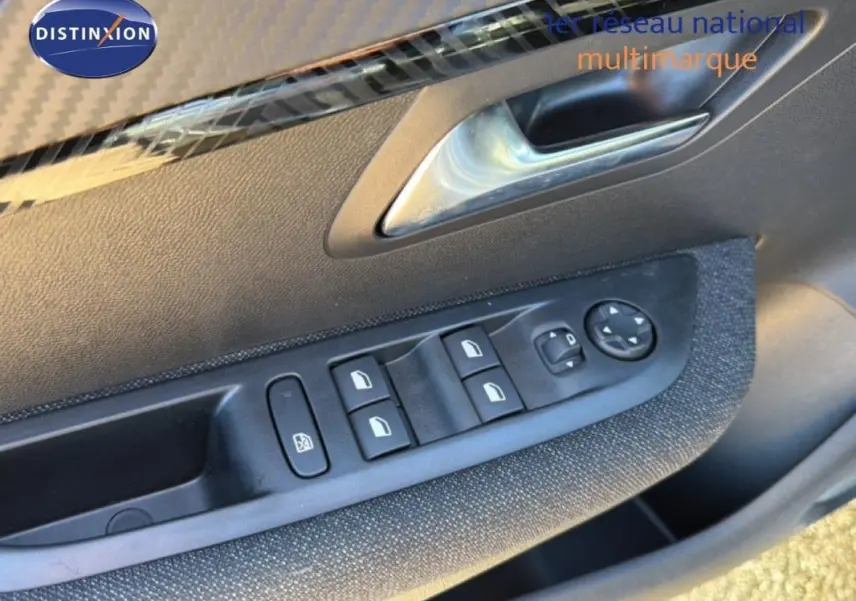 Gros plan sur la commande des vitres électriques et rétroviseurs côté conducteur d'une Peugeot 208 gris 2025.