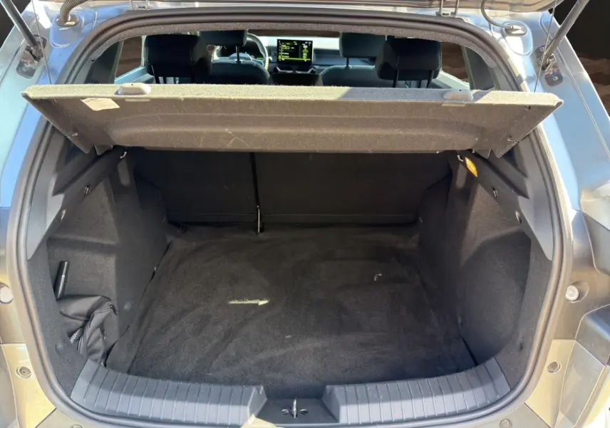 Coffre ouvert du Dacia Duster gris foncé, vue arrière montrant l'espace de chargement vide et la tablette de séparation.