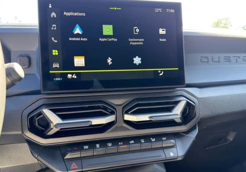 Vue rapprochée du tableau de bord du Dacia Duster gris foncé 2025, écran tactile avec Apple CarPlay et Android Auto.