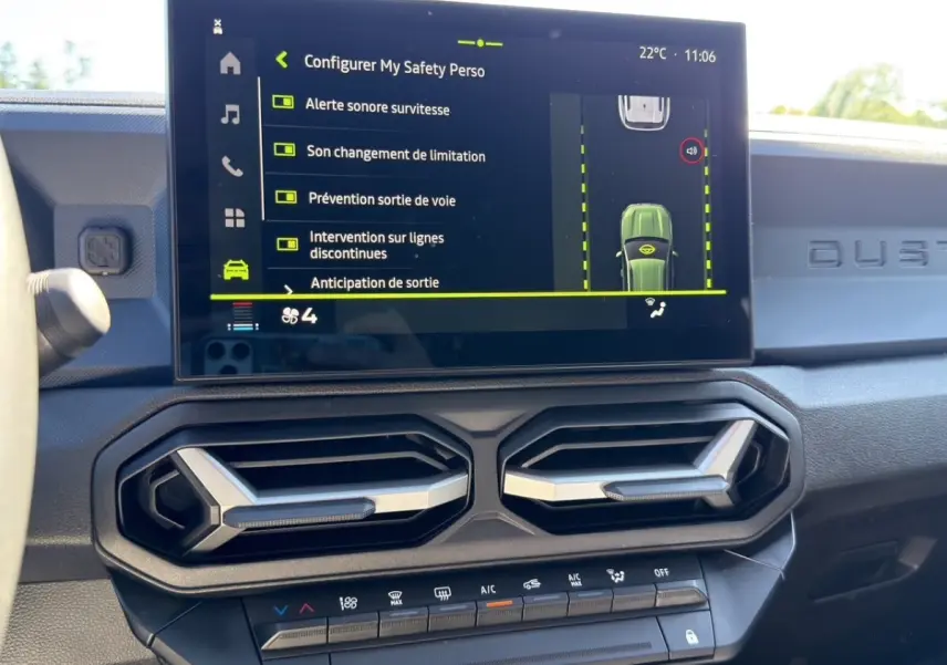 Vue intérieure du tableau de bord du Dacia Duster gris foncé, écran tactile affichant les aides à la conduite.