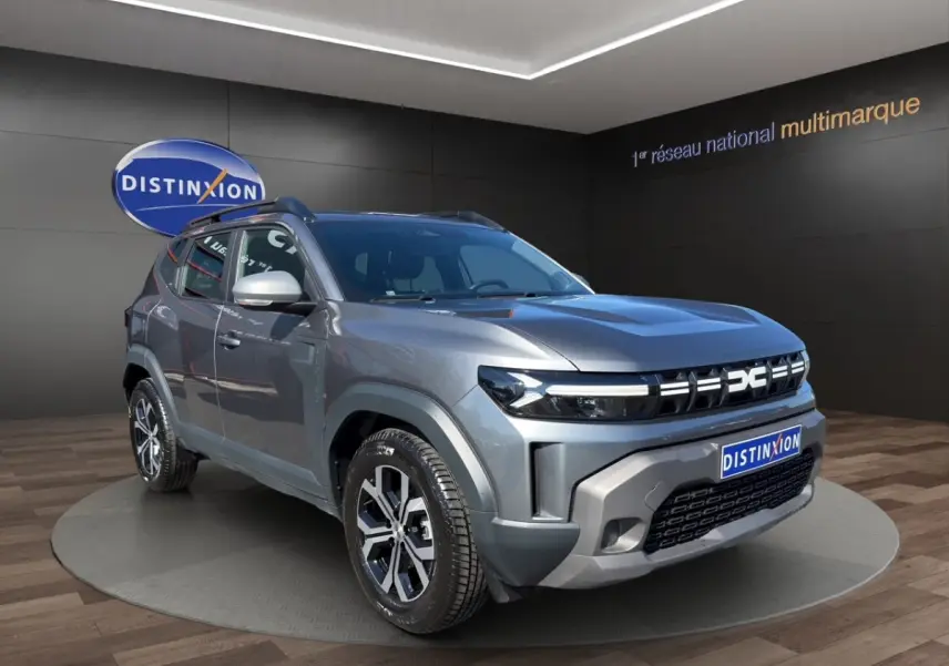 Dacia Duster gris foncé en 3/4 avant droit, avec calandre moderne et jantes alliage distinctives.