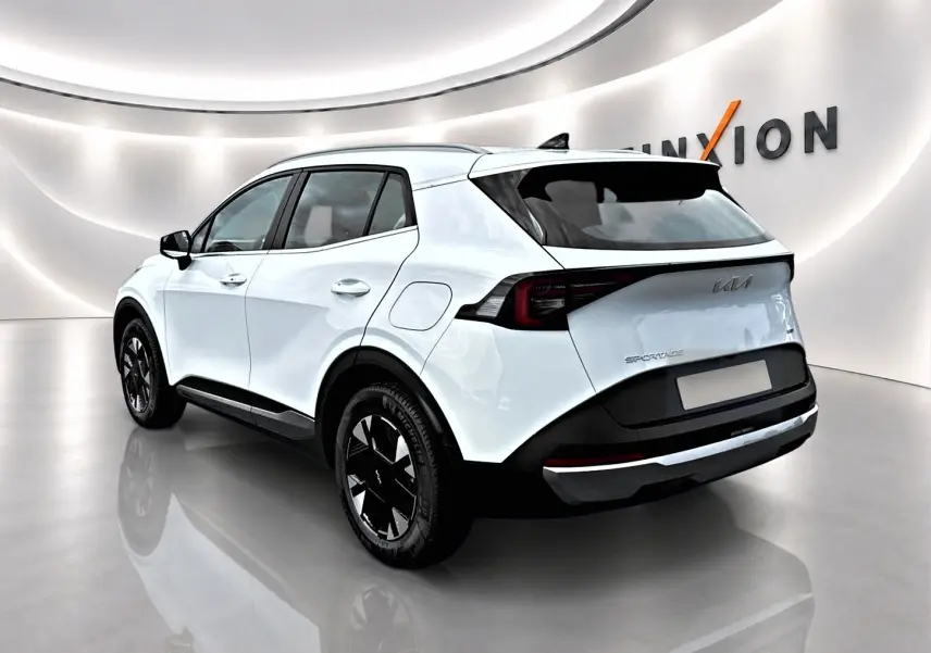 KIA Sportage 1.6 hybride blanc vu en 3/4 arrière droit, avec jantes alu noires et feux arrière LED distinctifs.