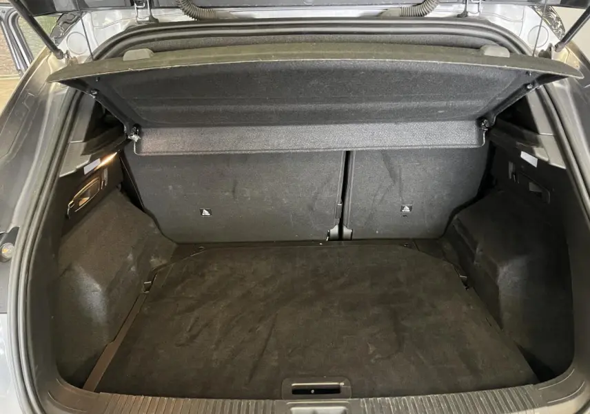 Coffre ouvert du Renault Austral gris, vue de l'arrière montrant le plancher et la banquette arrière rabattue.