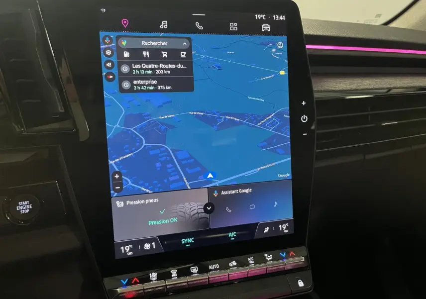 Écran tactile central du Renault Austral 2023 avec navigation et commandes climatisation, ambiance lumineuse rose visible.