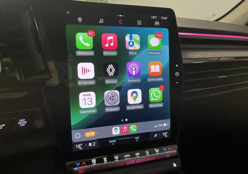 Écran tactile central du Renault Austral 2023 avec interface Apple CarPlay et ambiance lumineuse rose sur tableau de bord.