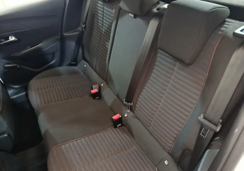 Banquette arrière noire avec surpiqûres rouges de la Peugeot 208 PureTech 100 vue côté gauche intérieur arrière.